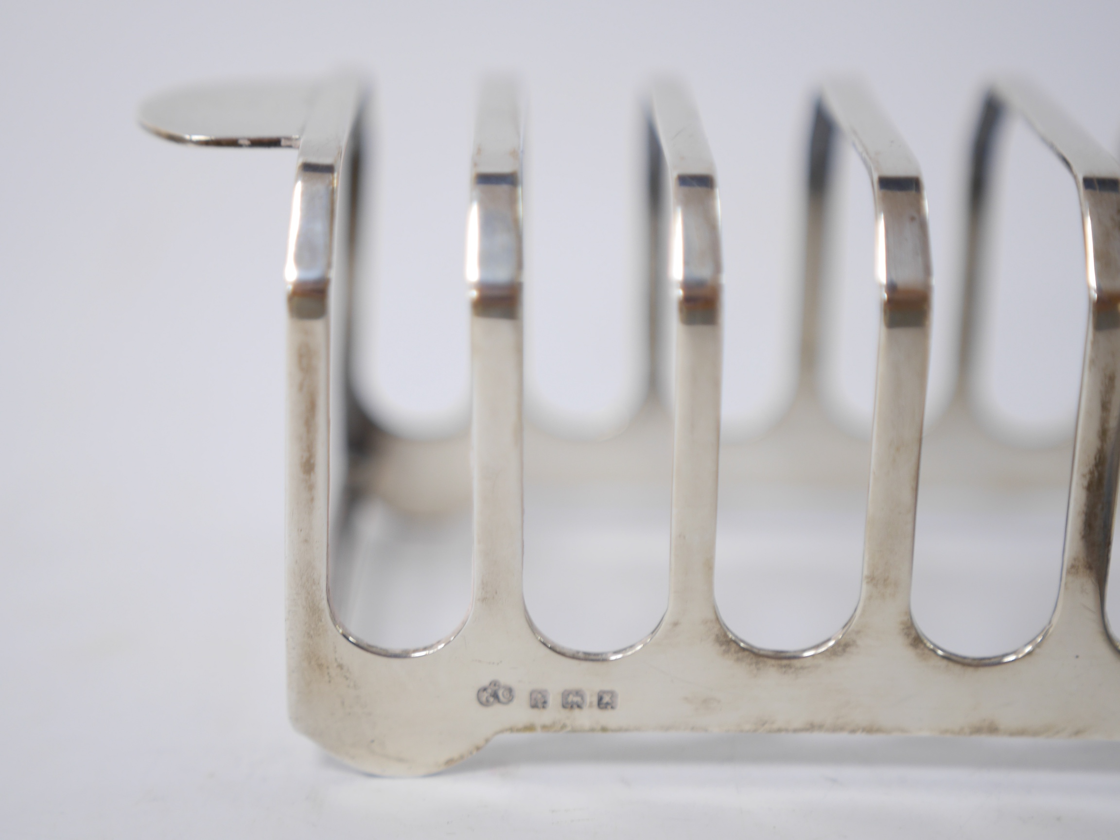 A George VI silver seven bar toast rack, by Elkington & Co, Birmingham, 1947, 14.9cm, together with a late Victorian silver clover shaped chamberstick, by Robert Pringle & Sons, Birmingham, 1899. Condition - fair to good